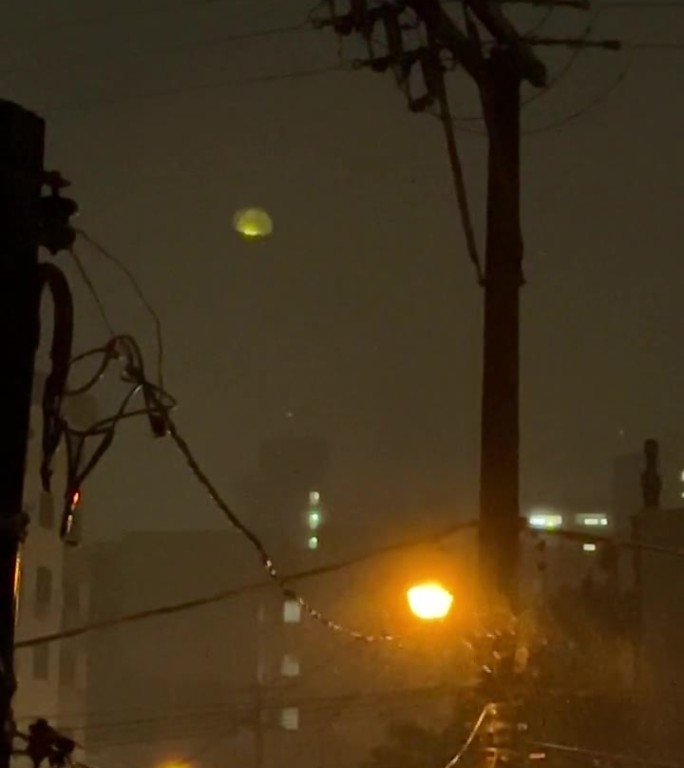 城市里有大雨，晚上有风，有路灯亮着