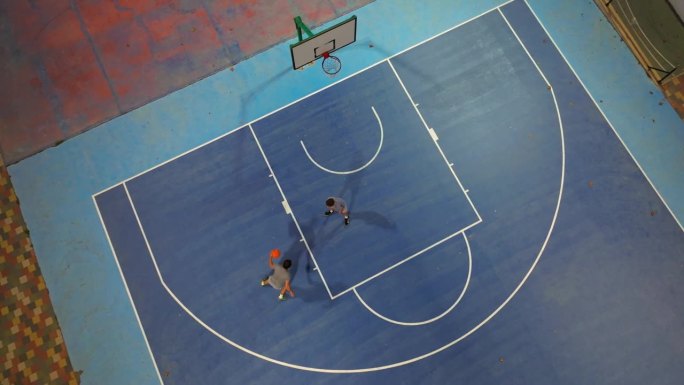 在外场打篮球。两个运动员在做运动，用球练习。运球