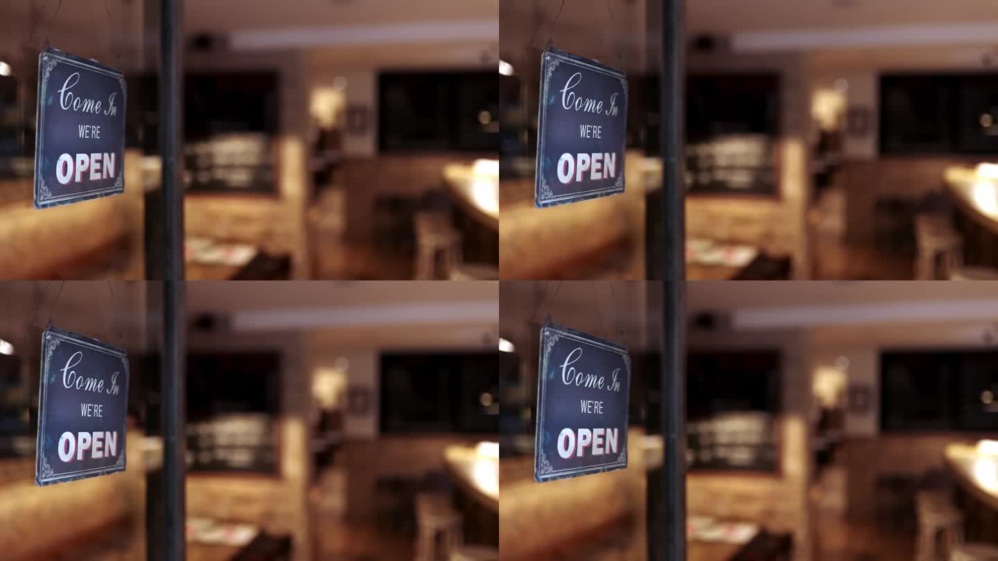餐厅入口的玻璃门上有我们是开放的标志。酒吧里的欢迎标志