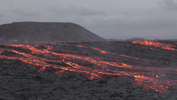 冰岛。火山喷发。炽热的熔岩正在蔓延。火山熔岩河的景观，从地球的地幔中喷出天然的热液体。全球变暖和气候