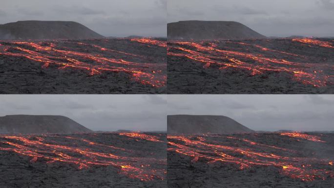 冰岛。火山喷发。炽热的熔岩正在蔓延。火山熔岩河的景观，从地球的地幔中喷出天然的热液体。全球变暖和气候