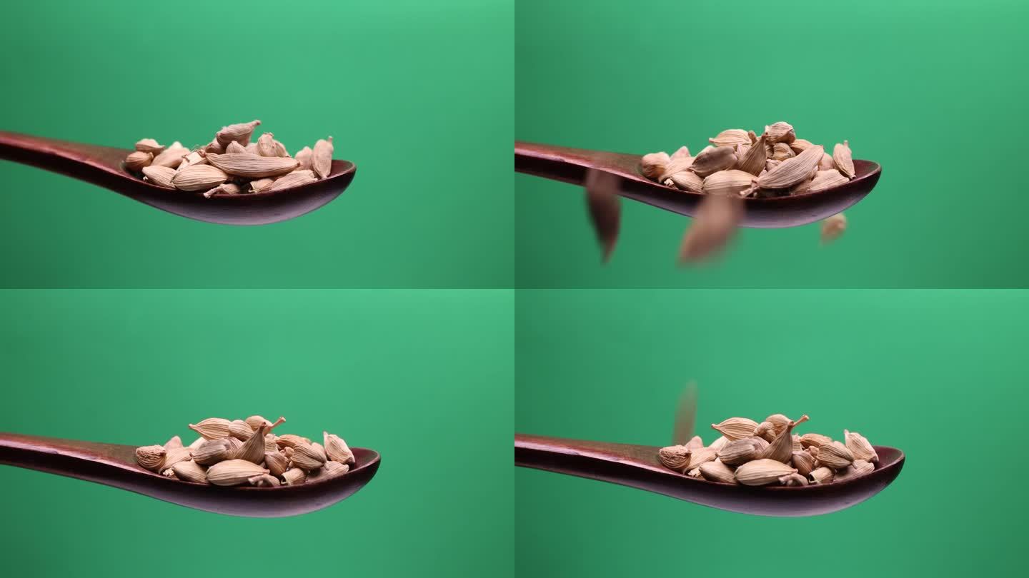 小豆蔻香香料豆荚木勺在绿色背景的特写下降下降旋转锅旋转运动移动