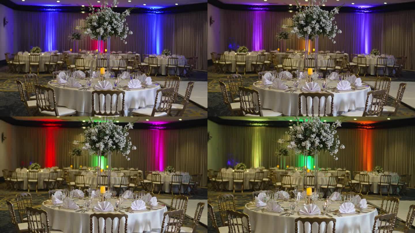 为婚礼装饰的圆桌，高大的中心饰有凤尾花、白玫瑰和绿叶。
