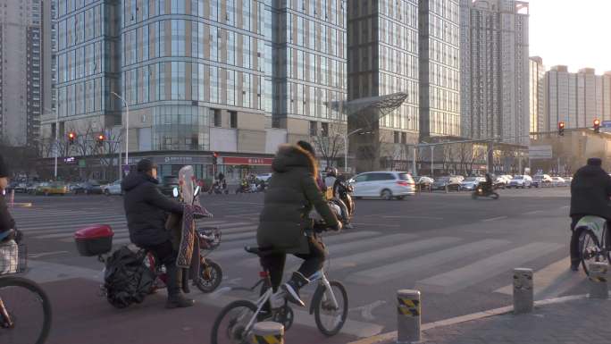 城市夕阳街道车流行人骑行下班晚夕阳过马路