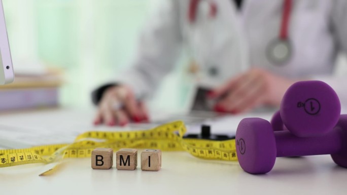 哑铃卷尺和单词BMI在木块和医生