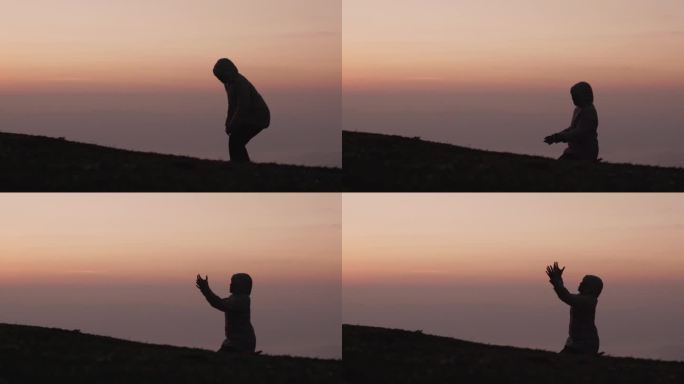 日出时，女人双手合十，做着祈祷的剪影。女性的生活方式跪着祈祷。慢动作视频。女孩双手合十，向上帝祈祷。