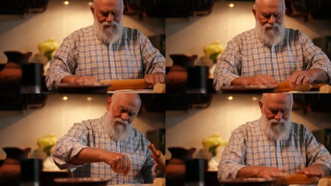 特写镜头。一位穿着衬衫、留着胡子的老人在一块木板上用擀面杖擀面。一个男人把面粉撒在擀好的面团上。在家