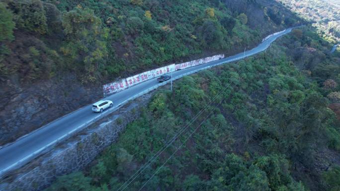 航拍崎岖山路行车路边标语