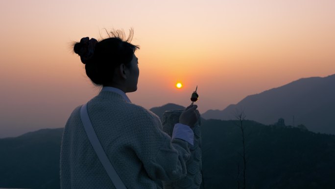 一个女孩在山顶看日落