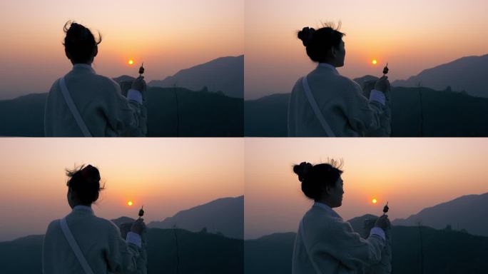 一个女孩在山顶看日落