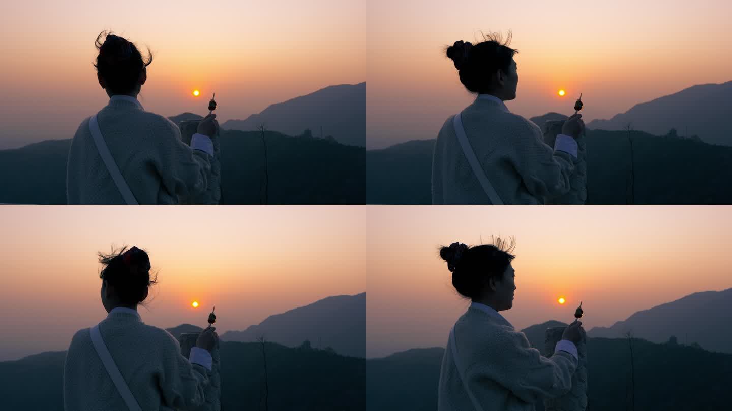 一个女孩在山顶看日落