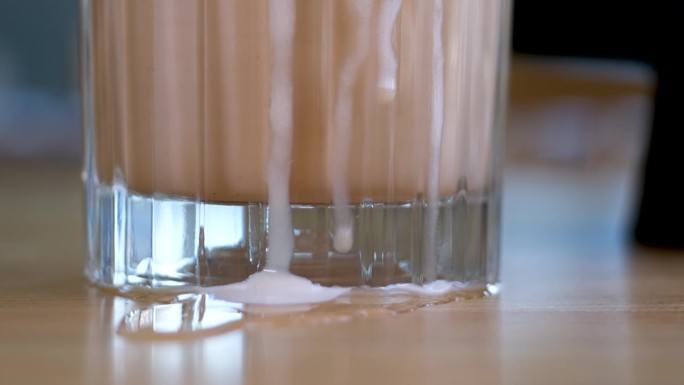 一杯加奶油牛奶的冰咖啡。加冰的冷萃咖啡饮料。清晨的阳光。冰沙加糖浆，咖啡加牛奶，美味的饮料，高泡沫，