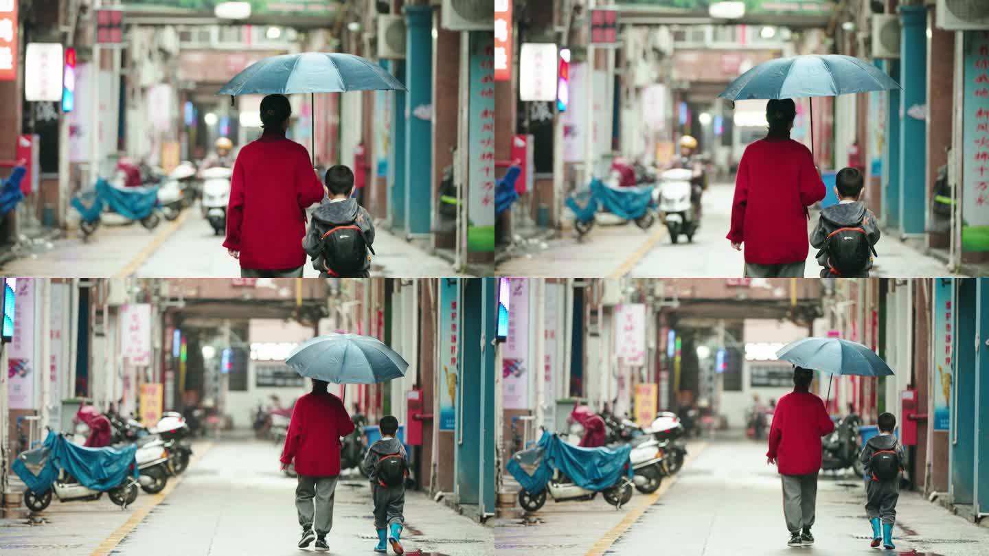 一对母子老街行走背影 妈妈给儿子撑伞