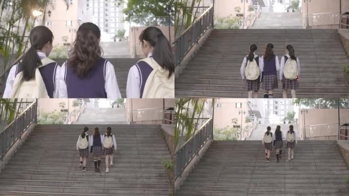 年轻女大学生蹦跳一起上学聊天爬楼梯背影