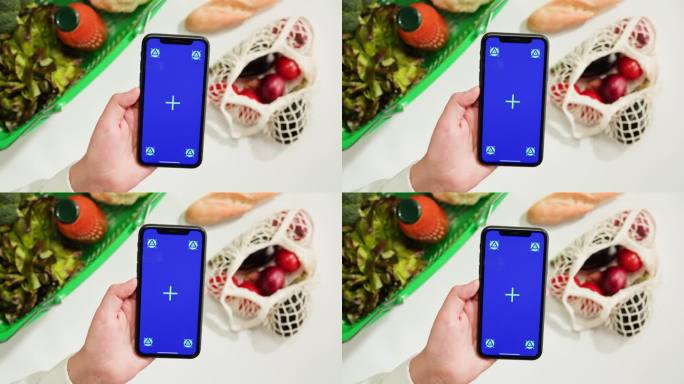 食品购物配送，网上商店应用，智能手机蓝色度键屏，新鲜蔬菜俯视图。在超市购买食品。