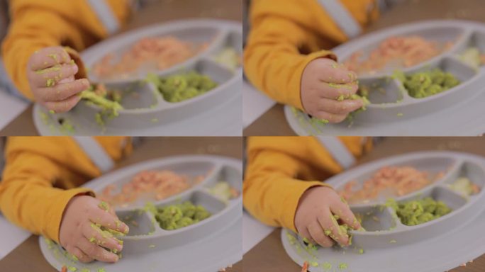 一个孩子的手从双酚a硅胶盘子里抓食物的特写
