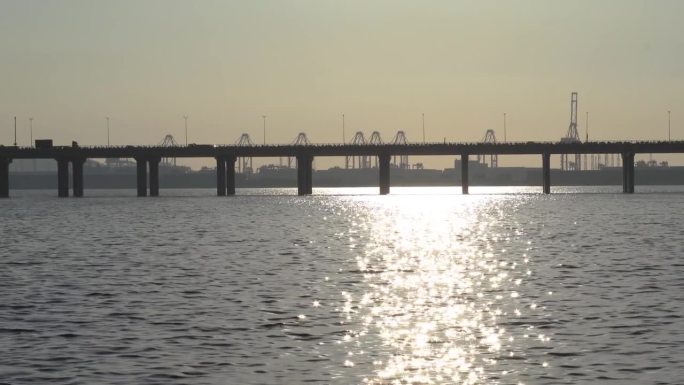 黄昏时横跨海洋的跨海大桥。平移镜头