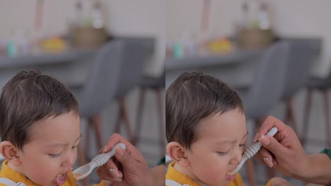 用勺子喂婴儿的脸部特写。婴儿辅食