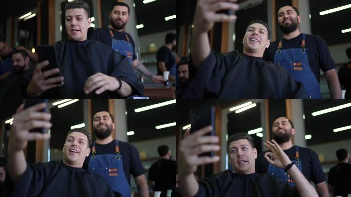 一名中年男子和他的理发师用手机为社交媒体录制视频