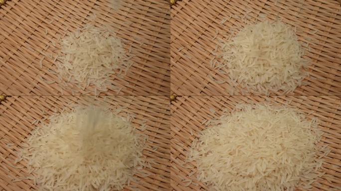 未煮熟的生白色长粒米倒落在竹盘旋转旋转锅