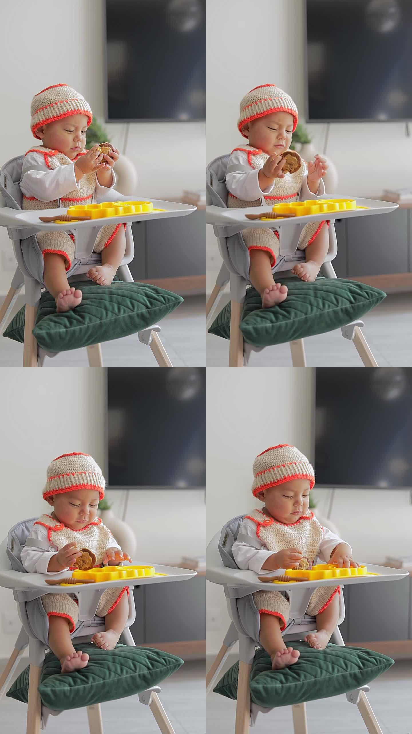 拉丁裔婴儿坐在椅子上用手吃东西。婴儿补充喂养。BLW