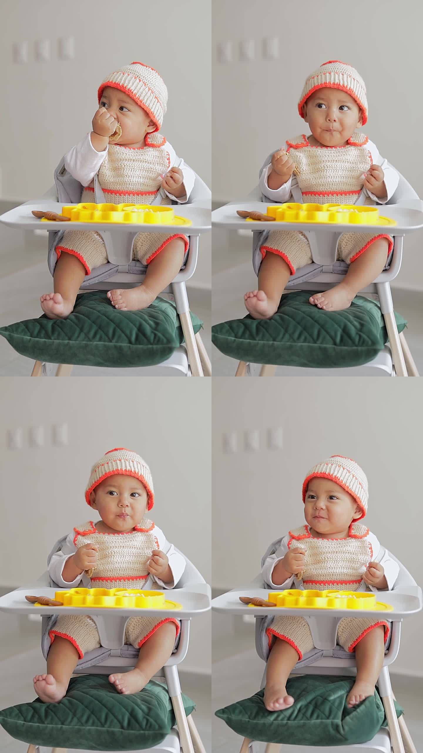 宝宝坐在椅子上用手吃煎饼的补充喂养。婴儿主导的断奶概念