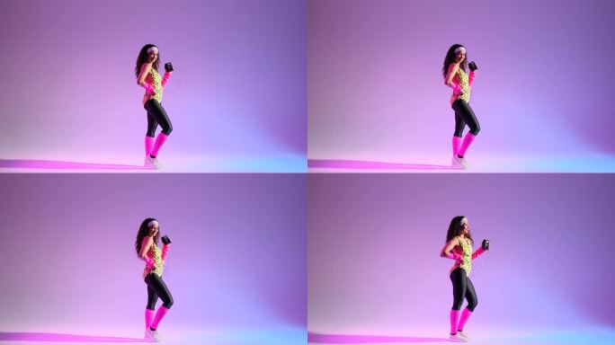 女人跳舞与个人立体声在紫色的背景