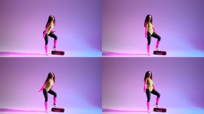 活跃的女人跳舞与Ghettoblaster在复古风格的紫色背景