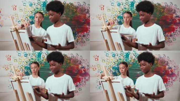 不同的快乐的孩子们一起画画布和染色的墙壁。启迪