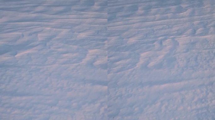 冬天的雪堆在夕阳下空旷的土地上被风塑造出抽象的雪的纹理