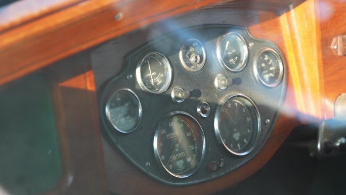 复古车的内饰细节。模拟仪表和表盘，在旧的木制仪表盘上