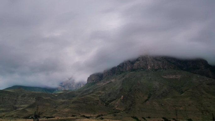 高原雄伟山脉的壮丽景色。间隔拍摄。浓密的雨云掠过山峰