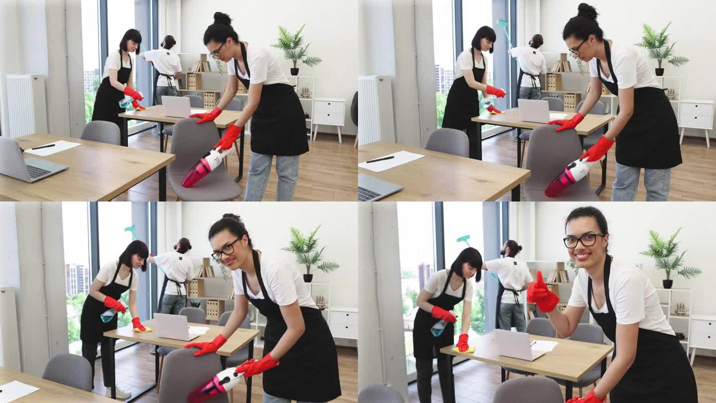 多民族女清洁工带便携式吸尘器的吸尘椅。