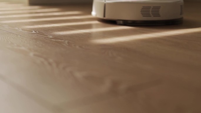 自动现代智能机器人真空吸尘器清洁木地板。智能家居，自动吸尘和清洗层压板，简化生活。管家。家庭设备。阳