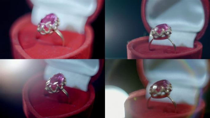 一枚漂亮的金戒指，红色的盒子里镶着一颗大红色的红宝石，在阳光下闪闪发光