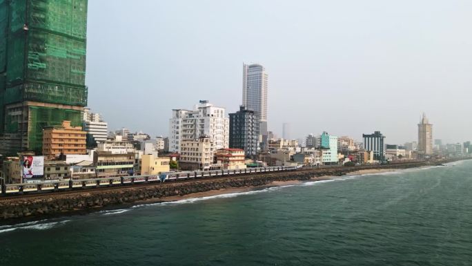 航拍的科伦坡天际线，有海洋、火车和城市交通。斯里兰卡首都景观，沿海城市景观。旅游、房地产、商业、影视