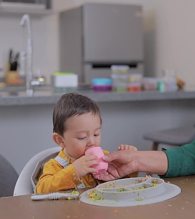 妈妈用硅胶杯给宝宝喂水。婴儿辅食