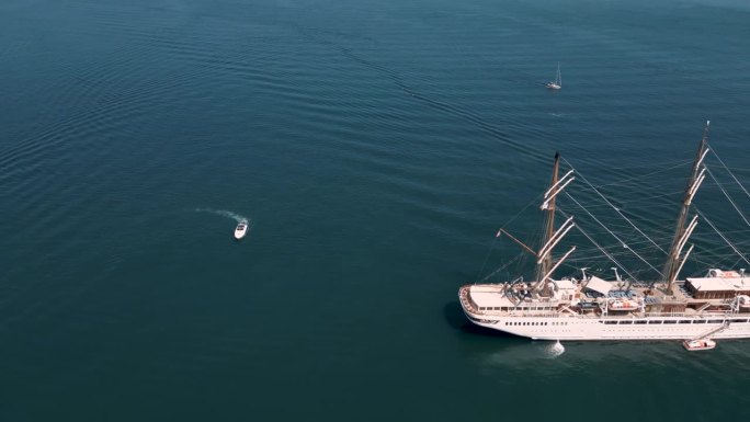从空中俯瞰豪华帆船停泊在平静光滑的海面上，小船和温柔的宁静场景，甲板和索具的细节。