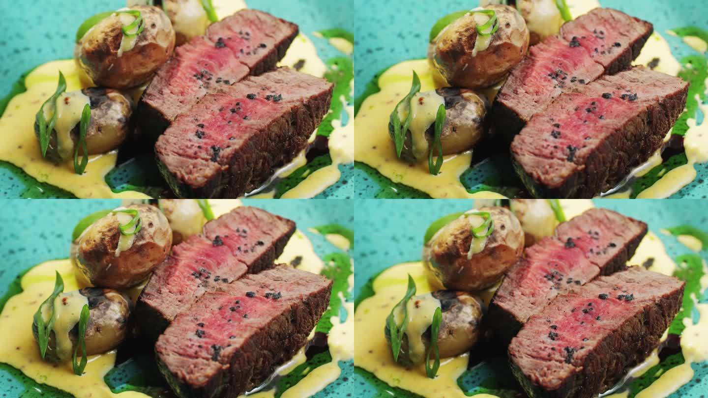 在昂贵的现代融合餐厅里，多汁的中牛肉肉肋眼牛排片配烤土豆，近距离享用精致的晚餐。