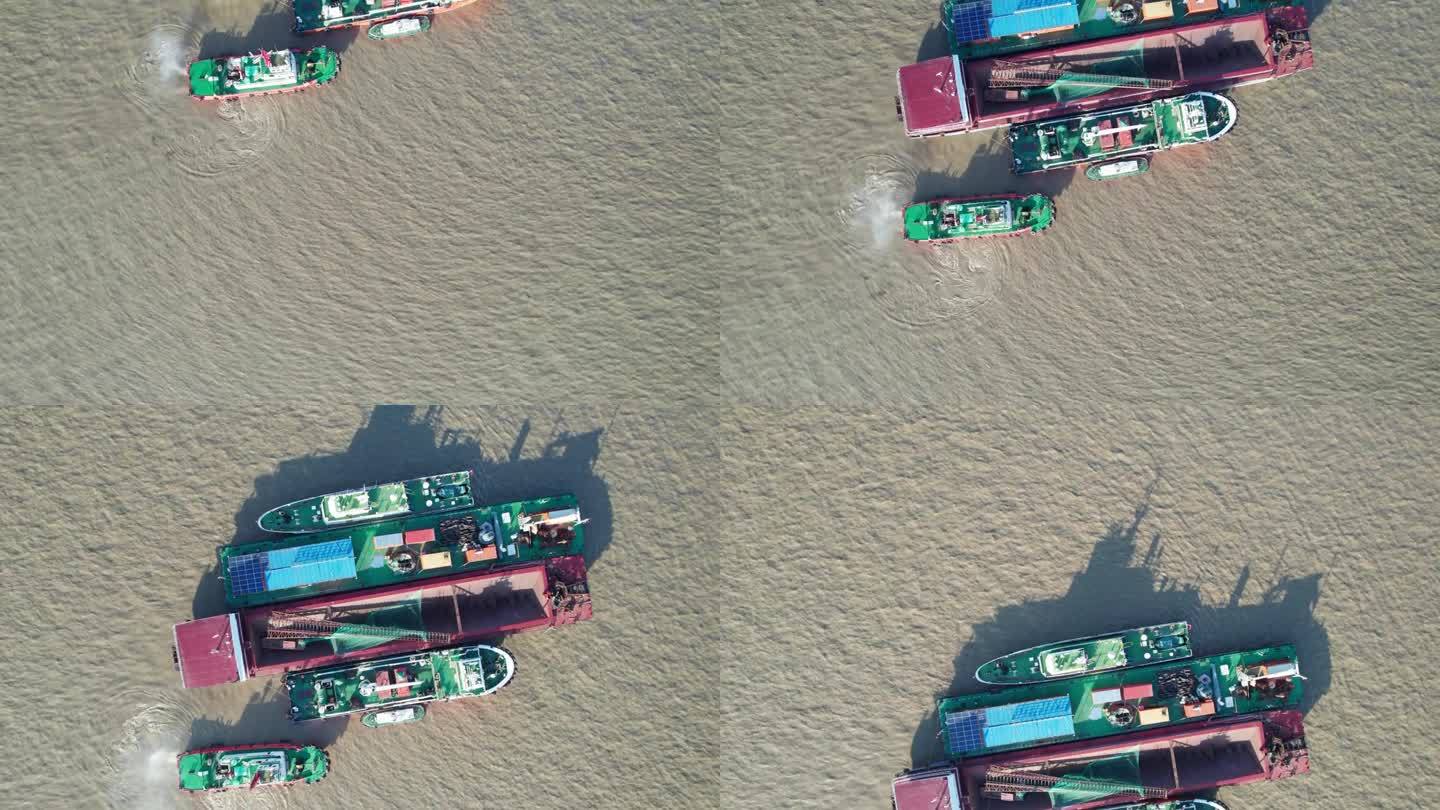 工业挖掘项目的高角度视图，在阳光明媚的日子里在河上工作的疏浚驳船，它的影子在水面上，无人机俯视图，4