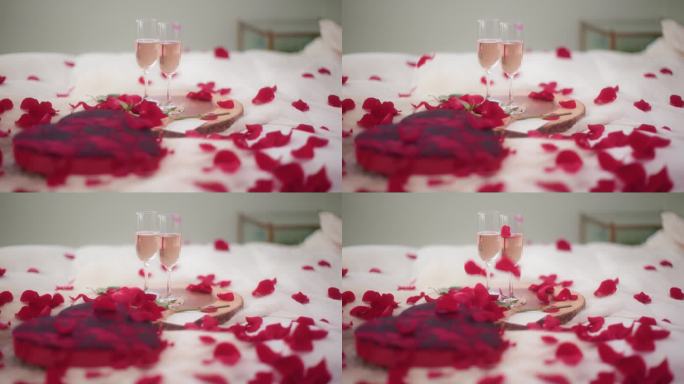 玫瑰花瓣落在情人节的卧室里，配上酒，慢动作