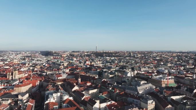 在蔚蓝的天空中，电影般的飞机飞过布拉格市红色的老城区屋顶