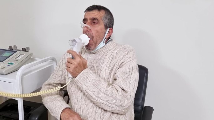 老人在医院做肺功能检查和肺活量测定。老年人用肺活量计测试呼吸功能