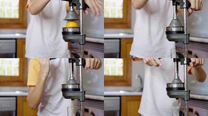在厨房做新鲜橙汁的少年。男孩用特殊的厨房压榨设备压榨柑橘汁。高品质4k画面