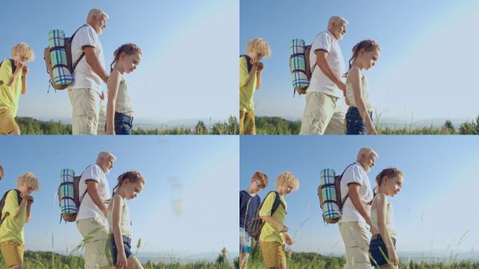 游客散步的侧视图，一起向前走，享受美好的阳光天气。老人背着背包走在前面，孩子们跟在后面。在山上旅行和