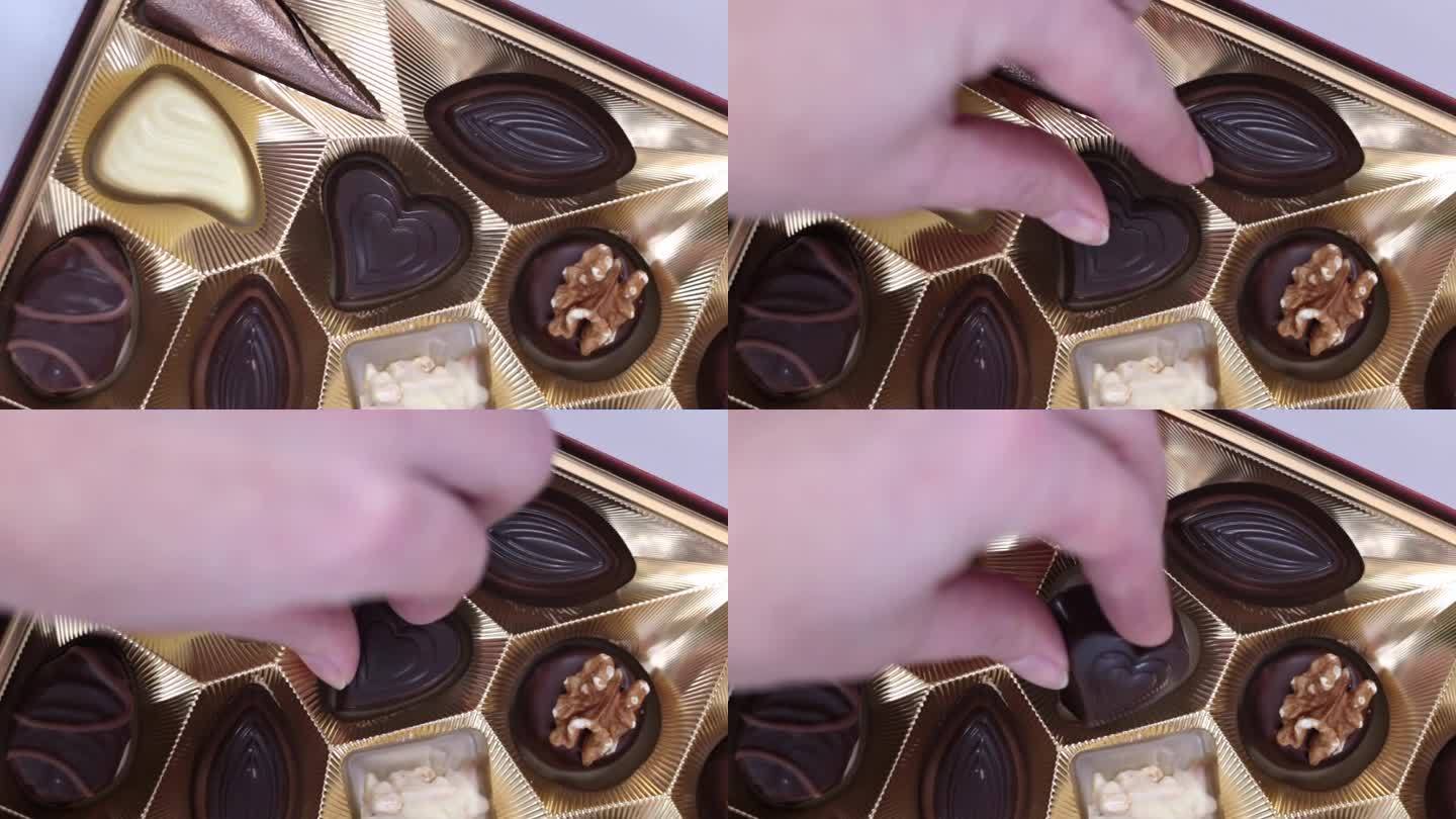 女孩从盒子里拿出一颗心形的巧克力糖。情人节概念