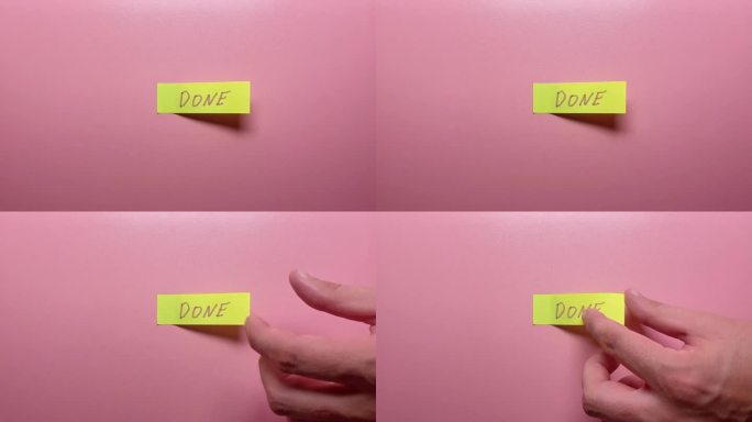 一只手撕下粉红色背景上写着“完成”的贴纸