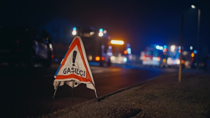 Gasilci路边的消防警告标志，消防车在夜间闪烁的背景灯