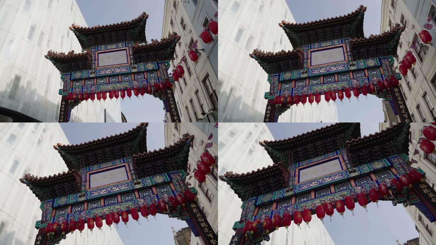 春日里，英国伦敦威斯敏斯特，一个人抬头看着挂着一串中国灯笼的唐人街大门