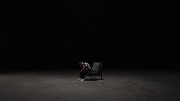 女人独自坐在黑暗中掩面悲伤